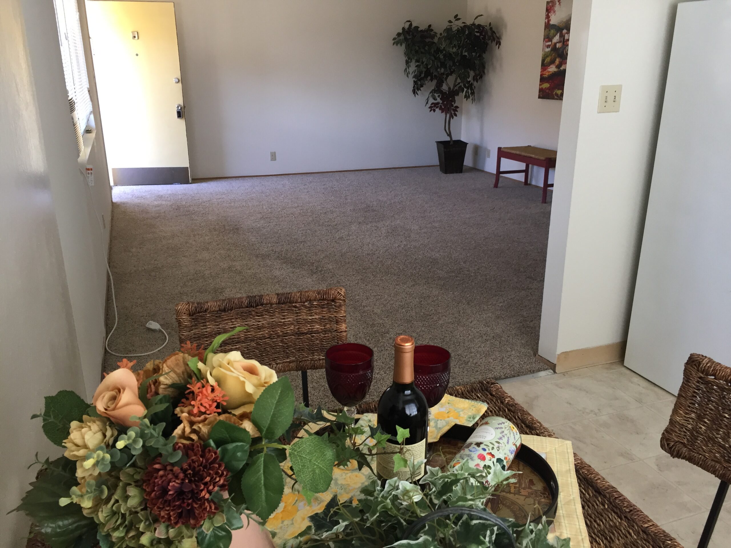 A room with flowers and wine on the table